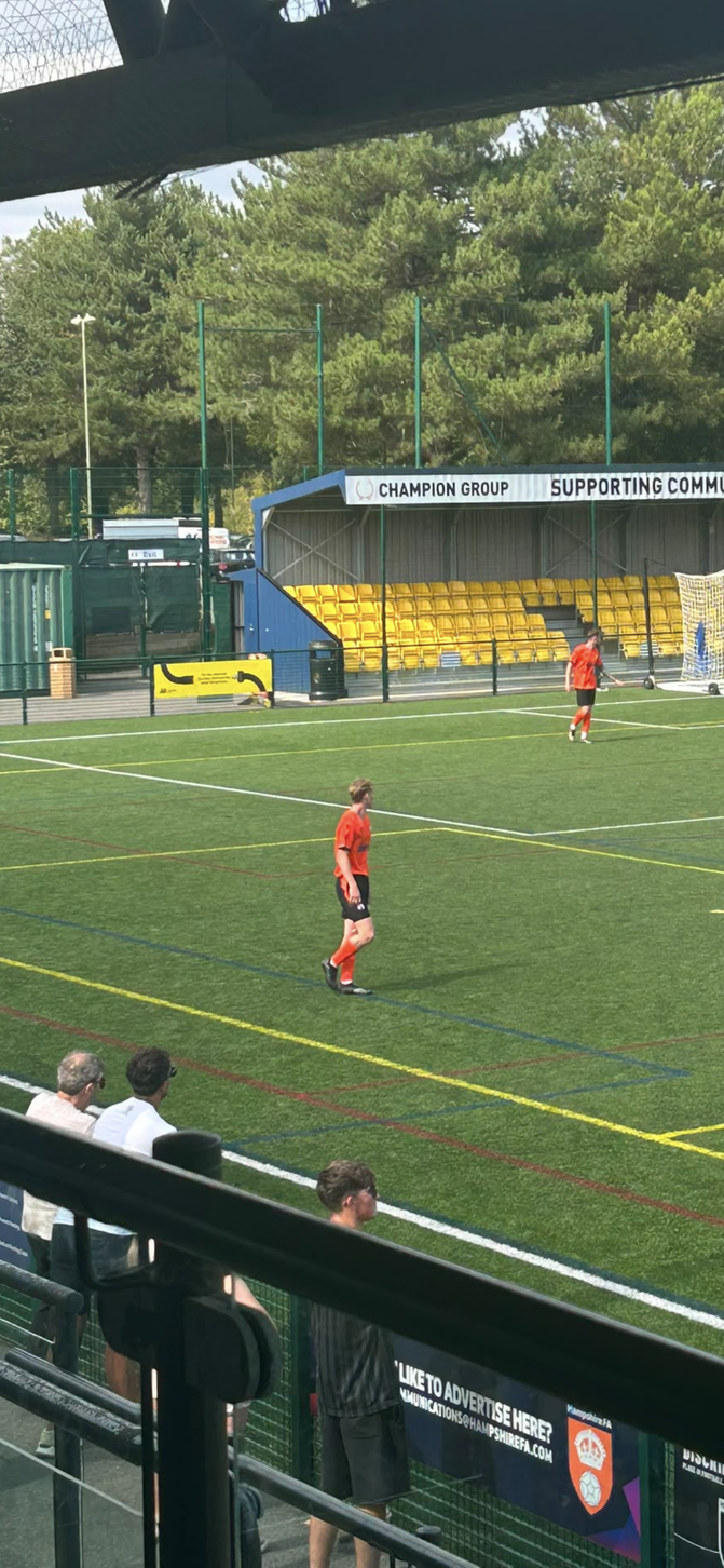 Whiteley players in orange shirts on the pitch during a match
