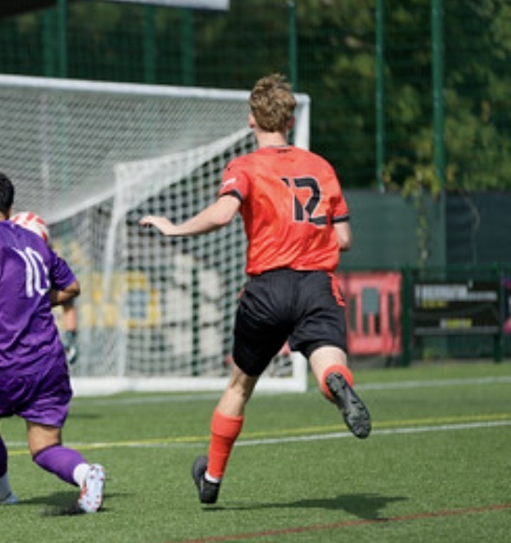 Whiteley number 12 chasing the ball towards goal alongside an opposing player